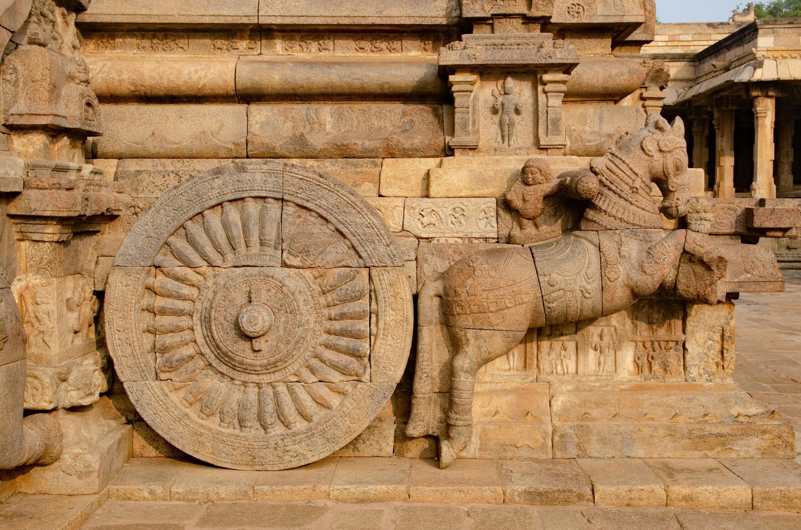 a statue of a horse with a wheel on it's back