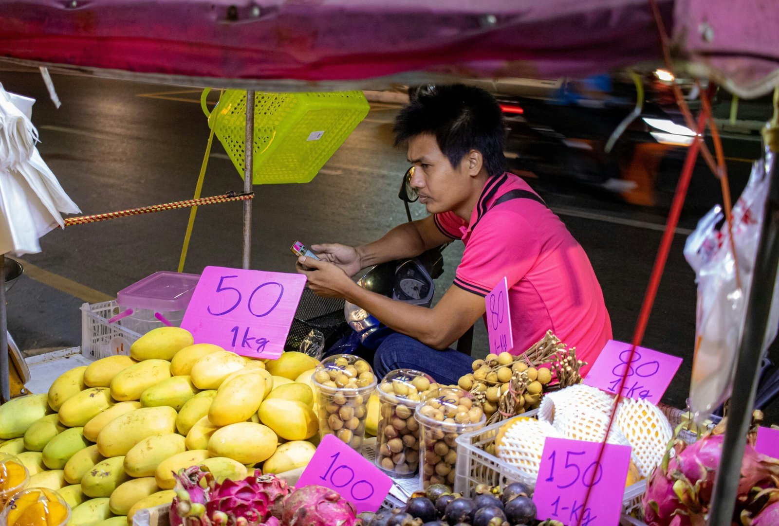 woman in pink long sleeve shirt holding purple paper bag with fruits